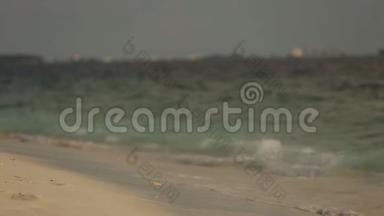 小海浪在马尔代夫热带海滩的沙滩上冲浪，特写镜头